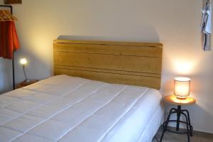 a bedroom with a large white bed and two lamps at Casa Aurora in Escusa