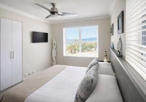 a bedroom with a large bed with a ceiling fan at Deja View in Knysna