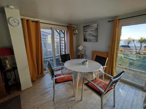 a dining room with a table and chairs and a window at Face à la mer in Châtelaillon-Plage