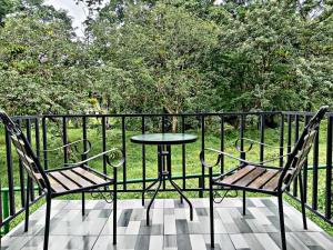 a table and two chairs sitting on a balcony at The Chicken House in El Castillo de La Fortuna +8 photos