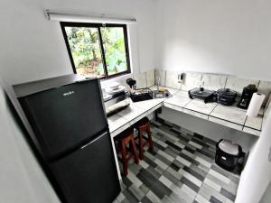 a small kitchen with a sink and a refrigerator at The Chicken House in El Castillo de La Fortuna