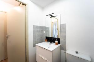 a bathroom with a sink and a mirror at Le Pacé - Appartement cosy in Pacé +3 photos