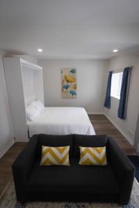 a bedroom with a black couch and a bed at Cozy Cove Retreat, Private Suite with Separate Entrance Near Friday Harbour, Barrie & Lake Simcoe in Innisfil