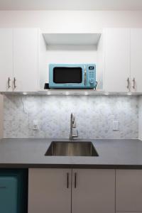 a kitchen with a sink and a microwave at Cozy Cove Retreat, Private Suite with Separate Entrance Near Friday Harbour, Barrie & Lake Simcoe in Innisfil