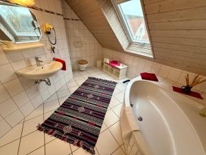 a bathroom with a bath tub and a sink at Landhotel am Mühlenwörth in Tauberbischofsheim
