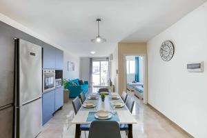 a kitchen and dining room with a table and a refrigerator at Bright & Spacious 3 Bedroom Apartment close to Marsaskala seafront in Marsaskala