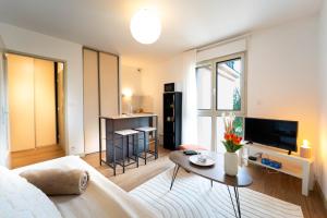 a living room with a couch and a table at Le Pacé - Appartement cosy in Pacé
