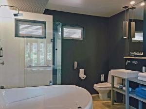 a bathroom with a bath tub and a toilet at Mercure Koh Chang Hideaway in Ko Chang