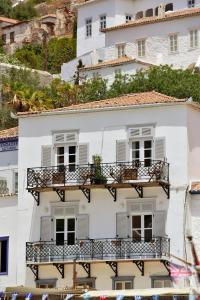 een wit gebouw met witte ramen en balkons bij NESEA VIEW Boutique Apartments in Hydra