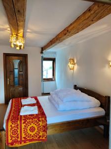 a bedroom with a bed with a red and white blanket at Wild-Traditional Bucovina in Câmpulung Moldovenesc
