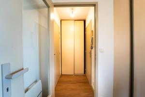a hallway with white walls and wooden floors at Le Pacé - Appartement cosy in Pacé