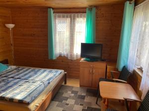 a bedroom with a bed and a flat screen tv at PanTuszka Pokoje in Pobierowo