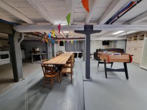 a room with a ping pong table and chairs at Gîte 6 personnes Chez Max in Nébouzat