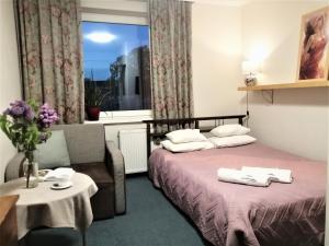a hotel room with a bed and a window at Pensjonat Landrynka in Darlowko +68 photos
