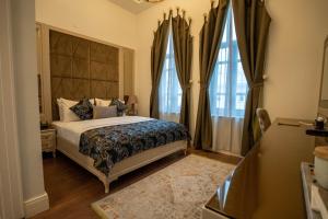 a bedroom with a large bed and two windows at BANDIRMA PALAS OTEL in Bandırma