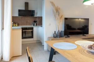 a kitchen and dining room with a table and a television at Ferienwohnung Allegra in Heinsberg +9 photos