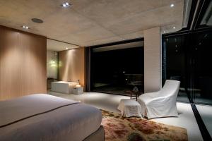 1 dormitorio con cama y ventana grande en Restio River House, en Pringle Bay