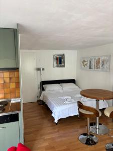 a small bedroom with a bed and a table at Cooles Apartment an der Kathedrale in Fribourg