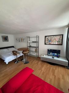 a bedroom with a bed and a table and a red rug at Cooles Apartment an der Kathedrale in Fribourg