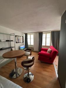 a living room with a red couch and a table at Cooles Apartment an der Kathedrale in Fribourg