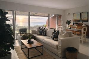 a living room with a white couch and a table at Salt & Still in Freeland Park