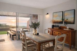 a dining room with a wooden table and chairs at Salt & Still in Freeland Park