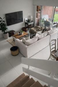 a living room with a white couch and a tv at Salt & Still in Freeland Park