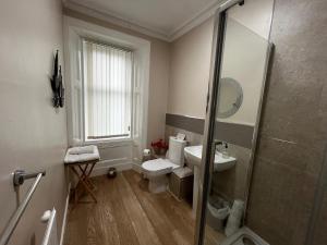 a bathroom with a toilet and a sink and a shower at Lomond Guest House in Leven