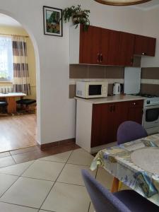 a kitchen and dining room with a table and a microwave at Zacisze Sokolec in Ludwikowice Kłodzkie