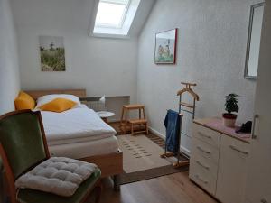 a bedroom with a bed and a chair and a dresser at Ferienwohnung Christel in Extertal