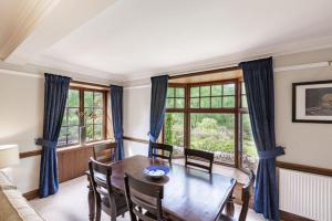 a dining room with a table and chairs and a window at Lonan Country House and Gardens in Taynuilt