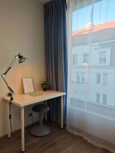 a desk with a lamp next to a window at Comfort flat with great location in Prague