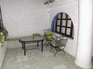 a patio with a table and chairs and a window at Casa Mablu in Chefchaouen