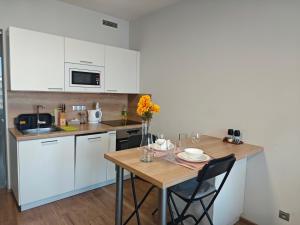 a kitchen with white cabinets and a wooden table at Comfort flat with great location in Prague +15 photos