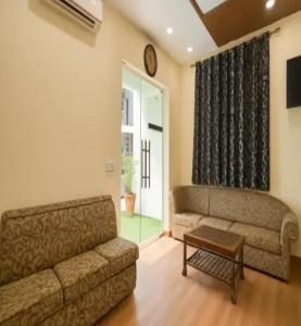 a living room with a couch and a table at Hotel Villa Getaway in New Delhi