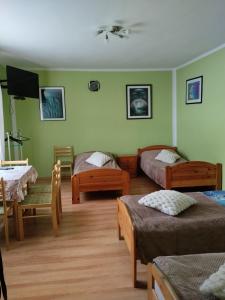 a room with two beds and a table and chairs at Zacisze Sokolec in Ludwikowice Kłodzkie