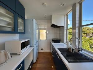 a kitchen with blue cabinets and a sink at Smile House Akiya in Hayama