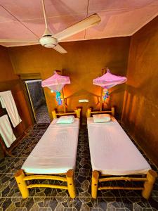 two beds in a room with umbrellas on the wall at Elephant paradise Safari resort in Udawalawe