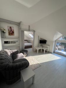 a living room with a couch and a tv at Pensjonat nad jeziorem Lakeside in Brodnica Dolna