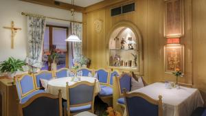 a dining room with two tables and a cross on the wall at Restaurant-Café-Pension Himmel in Landshut