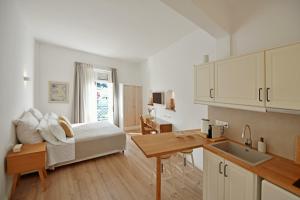 een slaapkamer met een bed en een keuken met een gootsteen bij NESEA VIEW Boutique Apartments in Hydra