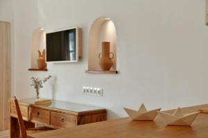 een eetkamer met een tafel en een tv bij NESEA VIEW Boutique Apartments in Hydra