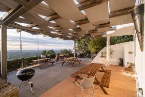 a patio with wooden benches and a grill at The Place at Evoramonte in Évora Monte +48 photos