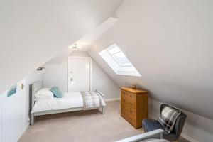 a attic bedroom with a bed and a chair at Lonan Country House and Gardens in Taynuilt