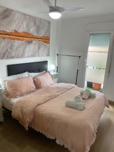 a bedroom with a large bed with two towels on it at PLAYA ALMARDA CORINTO, PISCINA, WIFI,2 TERRAZAS, BARBACOA,TRANQUILo in Sagunto +83 photos