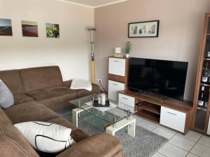a living room with a couch and a flat screen tv at Ferienwohnung im Kirchberg in Lieser