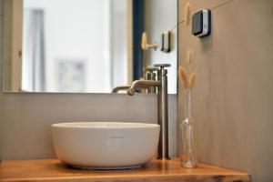 een kom die op het aanrecht naast een gootsteen staat bij NESEA VIEW Boutique Apartments in Hydra +22 foto's