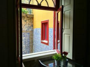 a window with a view of a room with red windows at Discovery | Porto-Flores in Porto