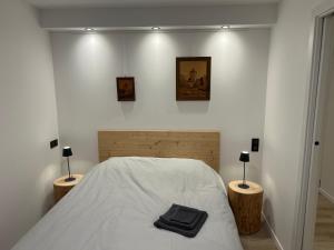 a bedroom with a white bed with two night stands at Maison climatisée indépendante et de plein pied in Bischoffsheim