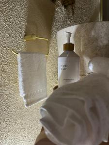 a bottle of soap on a table next to a towel at Écrin Secret - Suite troglodyte avec spa in Pia
